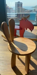 Uzm. Dr. İrem Oral klinik oyun & dinlenme alanı – ahşap tavşan kulaklı çocuk sandalyesi ve kırmızı sallanan at