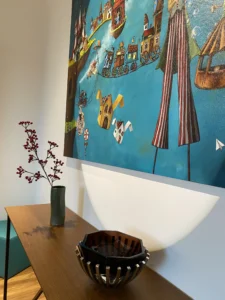 Uzm. Dr. İrem Oral Kliniği genel görünümü – renkli tablo, ahşap konsol masa ve dekoratif objeler