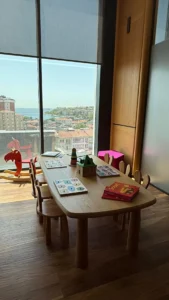 Minik hastalarımızın muayene öncesinde keyifli vakit geçirebileceği, ebeveynlerin ise dinlenebileceği; çocuk dostu masa, sandalyeler ve oyuncak köşesinin yanı sıra geniş camdan uzanan şehir ve deniz manzarasıyla ferah bir köşe.